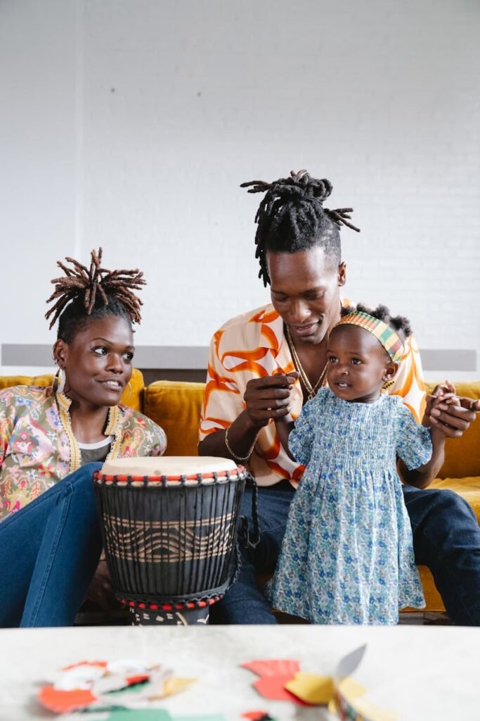 Joyful family enjoying music and togetherness in a cozy setting with a child and a djembe drum.