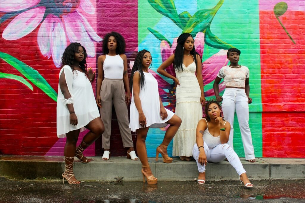 six women wearing white pants posing - pouvoir de la mélanine