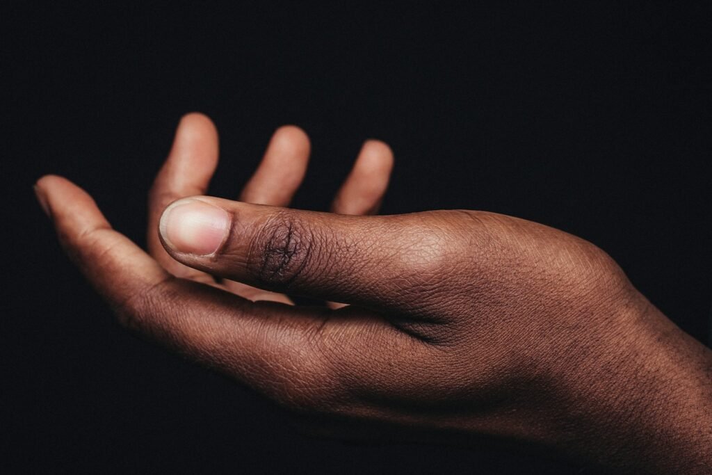 persons hand on black background - définition de mélanine