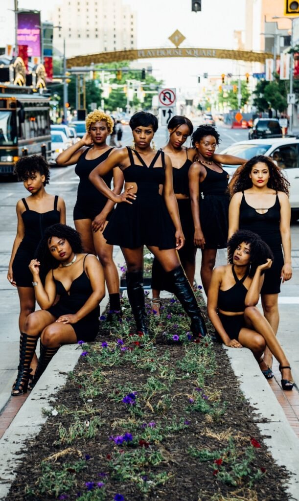 group of women in black tank top and black shorts sitting on concrete bench - définition de mélanine