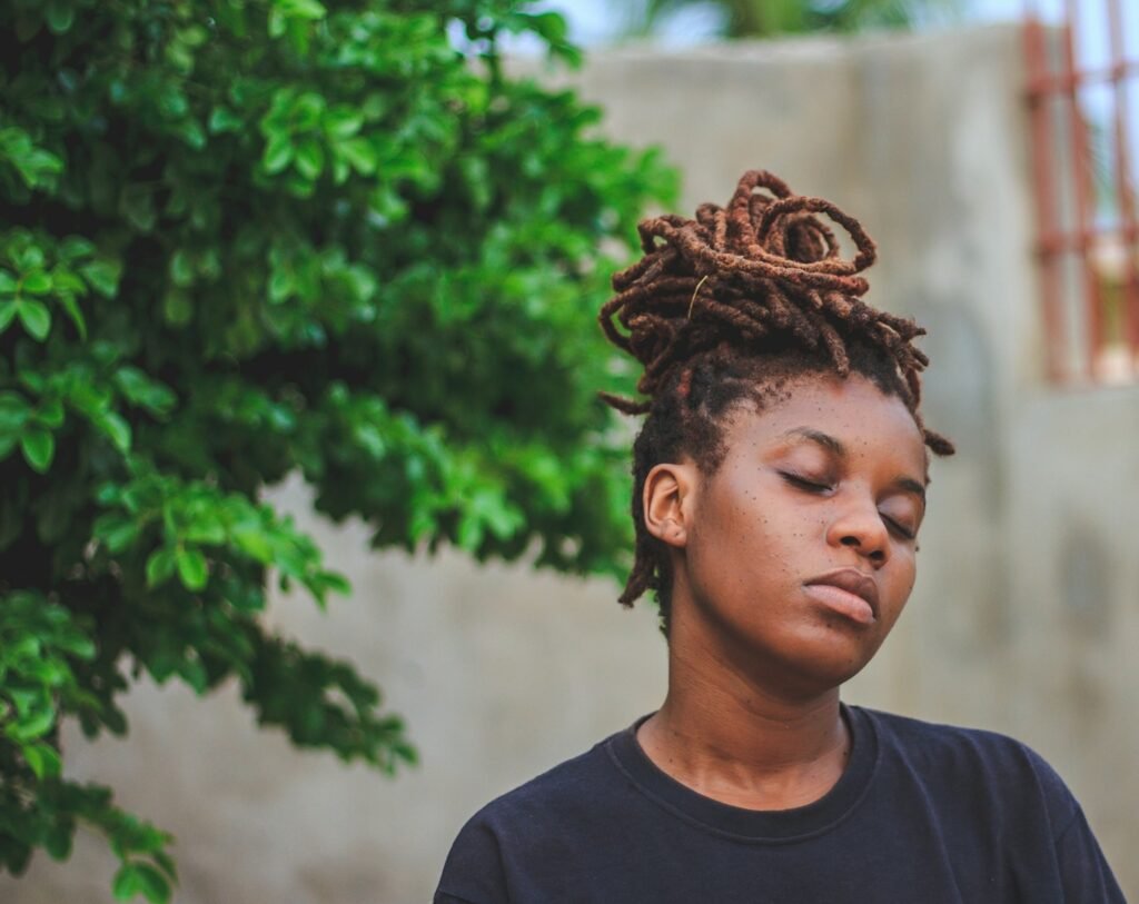 woman wearing black crew-neck shirt near green trees - locks