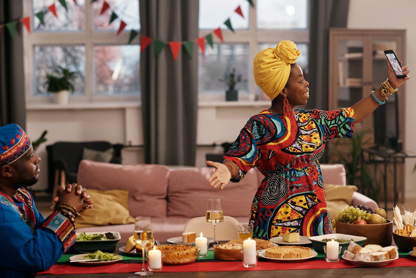 Festive Kwanzaa dinner with family video call, featuring traditional attire and cuisine. - 7 principes de kwanzaa