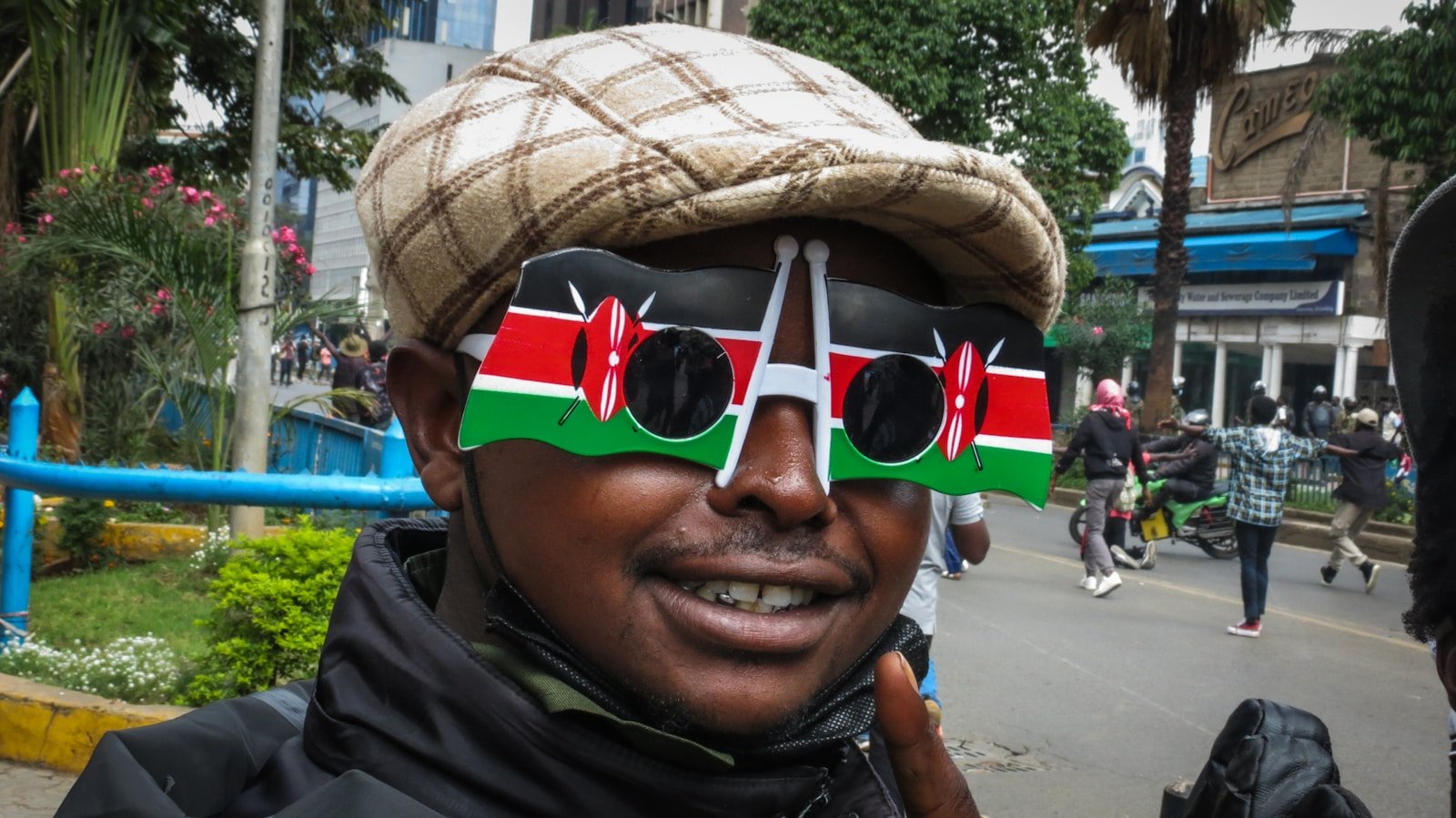 A man wears kenyan flag glasses.